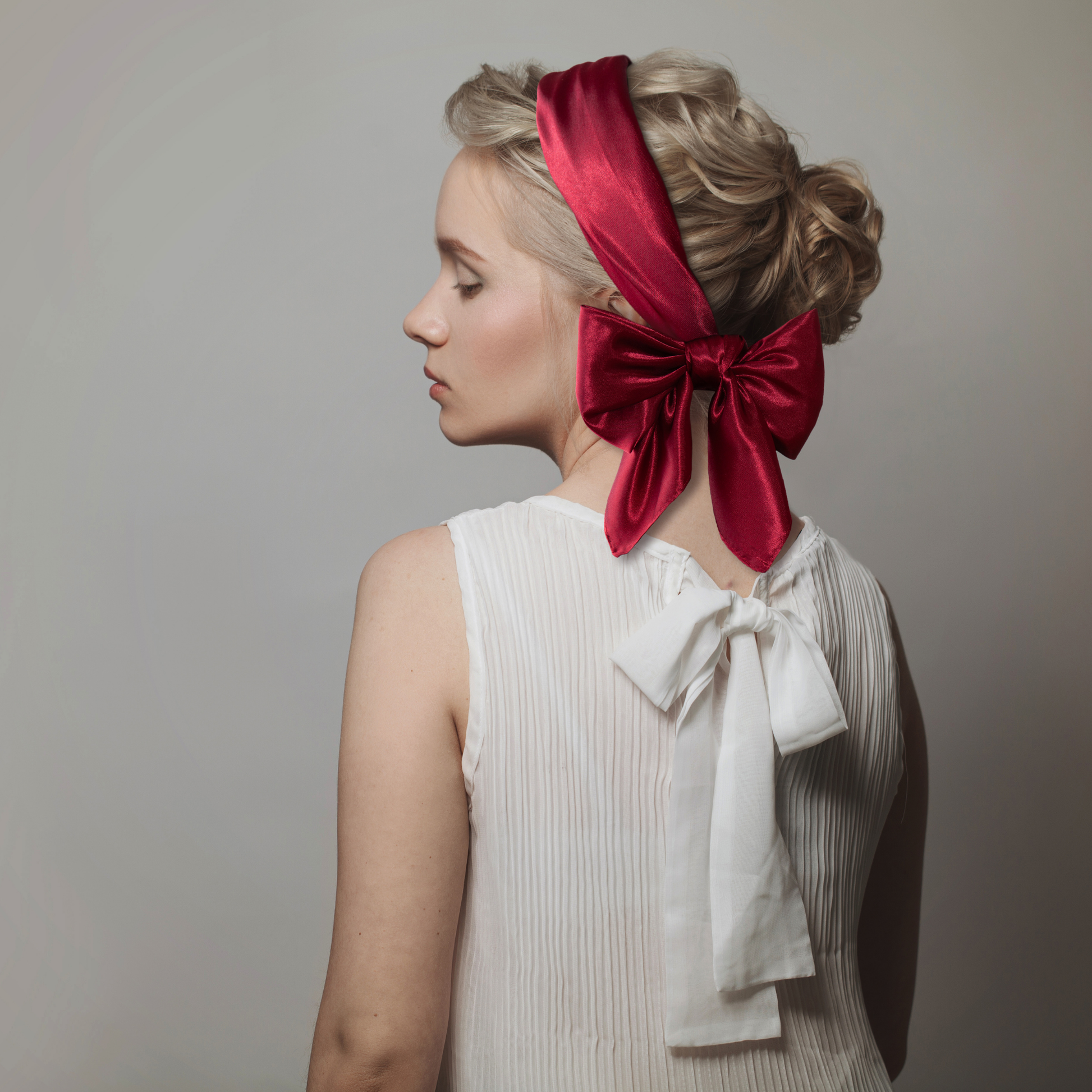 Woman wearing a red satin headband tied in a bow
