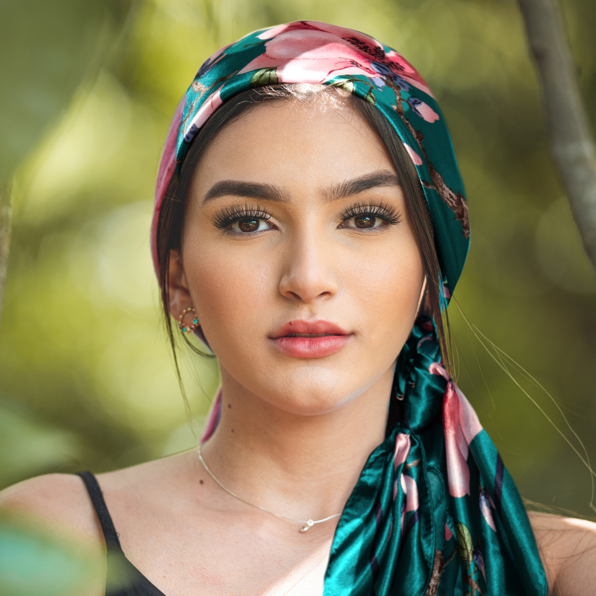 Woman wearing a colorful satin headscarf tied in a boho style