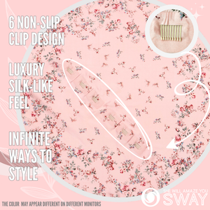 Small roses on a pink silky scarf laid flat with clips showing 